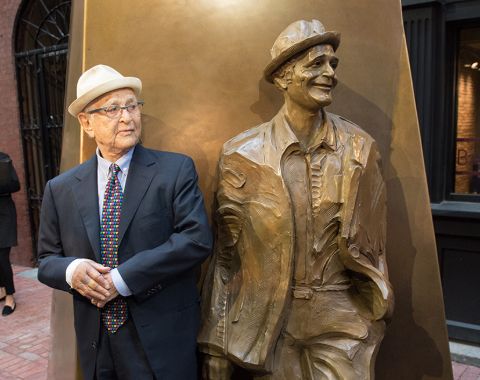 Norman Lear poses a picture with a statue.